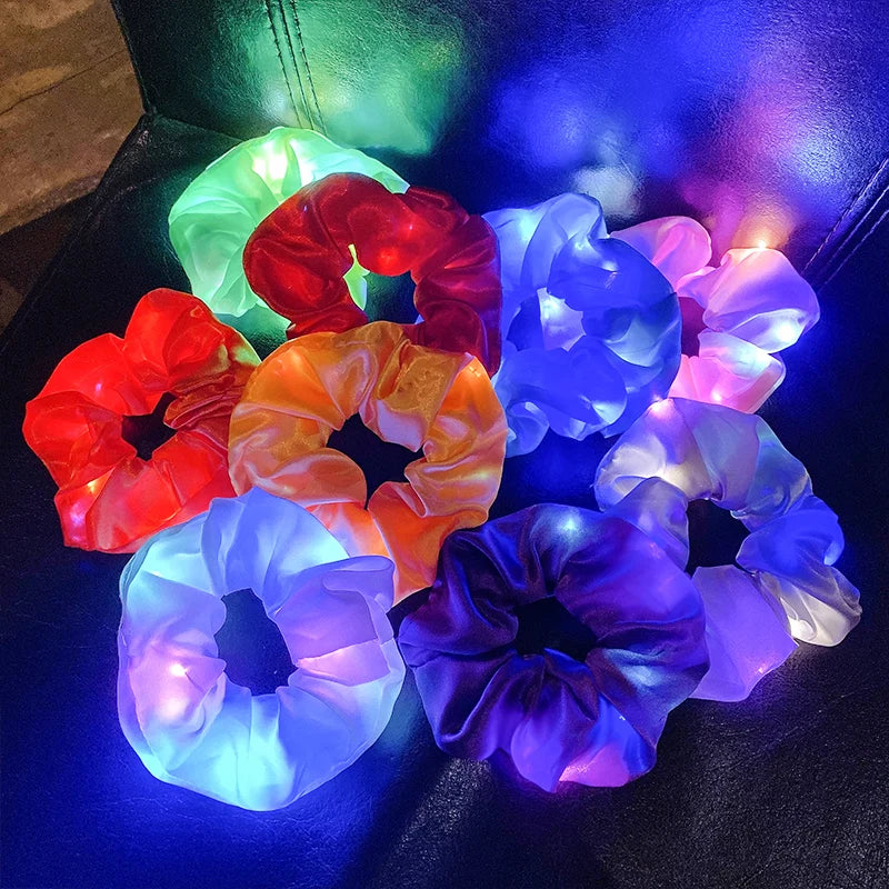 Nine LED light-up hair scrunchies of different fabric colors.