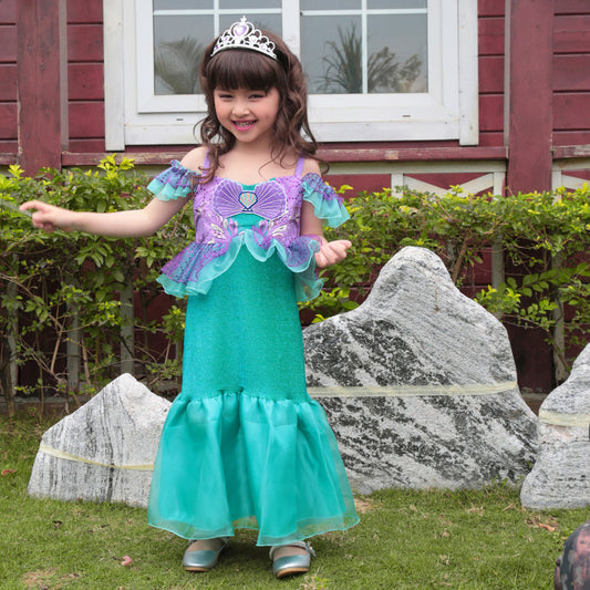 Mermaid gown in teal and purple with ruffle sleeves and waist with shell applique on girl.